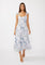 woman wearing a white floral maxi dress with cap sleeves and a fitted bodice