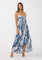woman wearing a blue and white floral maxi dress with a tie front and adjustable straps