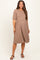 woman wearing a taupe maternity dress with puff sleeves and a tiered skirt, showing her baby bump