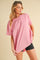 woman wearing a pink oversized t-shirt styled with black biker shorts and sunglasses