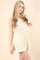 woman wearing a cream sleeveless knit tunic with a ribbed texture and side slits