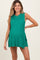 woman wearing a green ribbed maternity dress with side slits and a relaxed fit, showcasing her baby bump