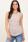 woman wearing a beige ribbed sleeveless tank top paired with blue jeans