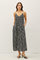 woman wearing a black floral maxi dress with adjustable straps and pockets, styled with black heeled sandals