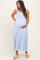 woman wearing a light blue gingham maternity maxi dress with adjustable straps and holding her baby bump