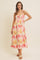 woman wearing a floral print midi dress with spaghetti straps and a gathered bodice, standing against a neutral background