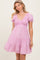 woman wearing a pink floral short sleeve smocked dress with a tiered skirt