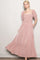 woman wearing a pink floral maxi dress with puff sleeves and a ruffled hem
