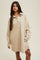 woman wearing a beige corduroy shirt dress with a front pocket and button-down closure