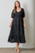 woman wearing a black puff sleeve maxi dress with a v-neck and tiered skirt