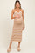 woman wearing a striped tan and white halter neck maternity dress, holding her baby bump