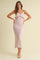 woman wearing a light pink knitted maxi dress with ruffle details and a fitted silhouette