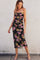 woman wearing a black floral strapless midi dress with ruching and side slit, styled with silver heels