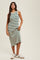 woman wearing a striped sleeveless midi dress in cream, green, and navy, styled casually with white sneakers