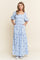 woman wearing a light blue floral maxi dress with puff sleeves and pockets