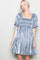 woman wearing a light blue short puff sleeve dress with a square neckline and smocked bodice