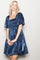 woman wearing a navy blue short puff sleeve dress with a smocked bodice and a flared skirt