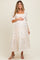 woman wearing a white floral maternity maxi dress with puff sleeves and a baby bump visible