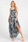 woman wearing a white and navy floral maxi dress with a high slit and spaghetti straps