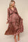 woman wearing a brown leopard print maternity maxi dress with long sleeves and a v-neckline, highlighting her baby bump