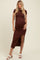 woman wearing a brown short sleeve maternity dress with side ruching and a thigh-high slit, showing her baby bump