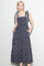 woman wearing a navy blue floral print midi dress with tie shoulder straps and side pockets