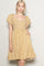 woman wearing a mustard yellow floral print dress with ruffle sleeves and a square neckline