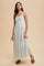 woman wearing a light blue floral maxi dress with a square neckline and thin straps