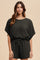 woman wearing a dark green short sleeve knit romper with a drawstring waist