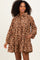 woman wearing a brown floral print long sleeve dress with a tiered skirt and pockets