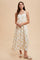 woman wearing a cream floral maxi dress with adjustable straps and a gathered waist, styled with sandals