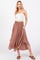 woman wearing a cream spaghetti strap top and a dusty rose maxi skirt with a smocked waistband and side pockets