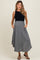 woman wearing a black sleeveless top and a flowy gray maternity skirt with side pockets
