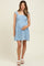woman wearing a light blue floral maternity dress and holding her baby bump