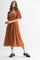 woman wearing an orange ribbed midi dress with puff sleeves and a square neckline, paired with black loafers and white socks