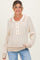 woman wearing a cream and beige striped maternity sweater with button details and relaxed fit