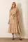 woman wearing a beige tiered maxi dress with short puff sleeves and a tie waist detail
