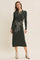 woman wearing a dark green ribbed midi dress with a collar and contrast tie at the waist, styled with ankle boots