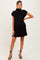 woman wearing a black maternity dress with a mock neck and relaxed fit, showcasing her baby bump