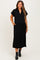 woman wearing a black short sleeve maternity dress with a collar and side pockets, showcasing her baby bump