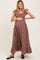 woman wearing a purple floral maternity maxi dress with ruffled sleeves and holding her baby bump