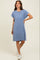 woman wearing a blue striped short sleeve dress with a pocket and white sneakers