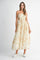 woman wearing a light yellow floral maxi dress with spaghetti straps and scalloped edges