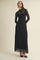 woman wearing a black lace long sleeve maxi dress with a high neckline and fitted silhouette