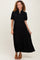 woman wearing a black button-up maxi dress with puff sleeves and tiered design, standing and smiling