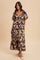 woman wearing a navy floral maxi dress with puff sleeves and a tiered skirt, standing against a neutral background