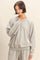 woman wearing a gray oversized sweatshirt with a crew neckline and relaxed fit