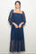 woman wearing a navy lace maxi dress with puff sleeves and a fitted bodice