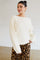 woman wearing a cream oversized sweater with lace detail on sleeves and a leopard print maxi skirt