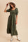 woman wearing an olive green tiered maxi dress with puff sleeves and cowboy boots, standing against a beige background